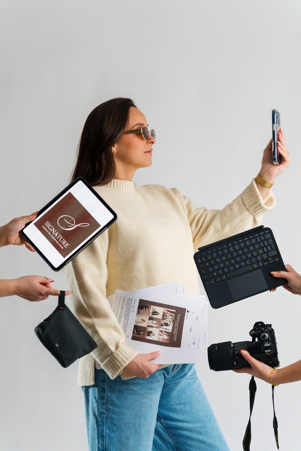 Portrait de marque pour l'agence Signature : une femme en lunettes de soleil prend un selfie, entourée d'objets de création