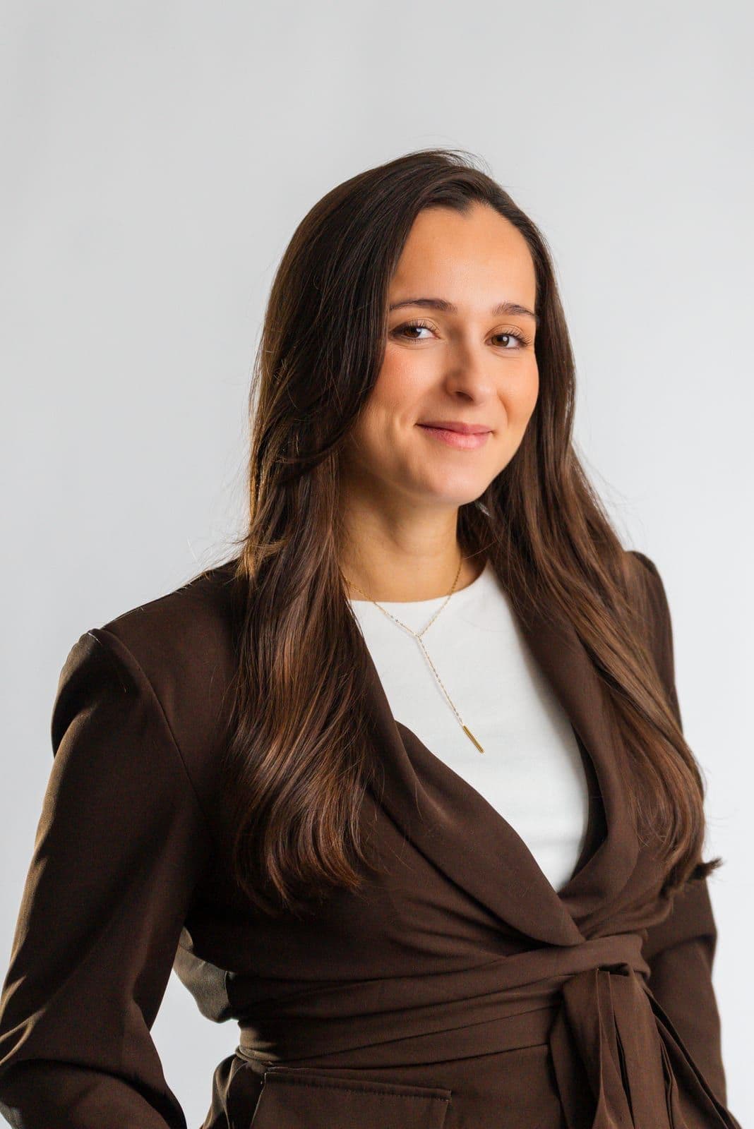 Portrait de Marie Calasnives, community manager, en blazer marron sur fond blanc